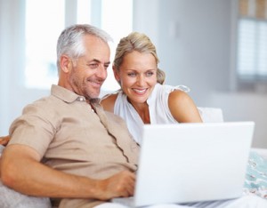 A happy aged couple surfing on a laptop